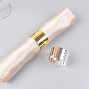 Polished gold and silver napkin rings on champagne silk napkins for elegant table setting