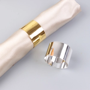 Close-up of polished gold and silver napkin rings with a glossy metallic mirror finish