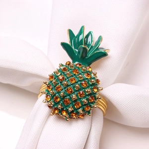 Détail du rond de serviette ananas avec feuilles émaillées vertes et strass orange