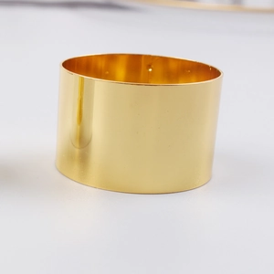 Polished gold wide metal napkin ring with a reflective mirror finish for table decor