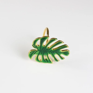 Détail macro du rond de serviette feuille de monstera avec émail vert et finition dorée