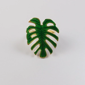 Détail du rond de serviette feuille de monstera tropicale avec finition dorée et émail