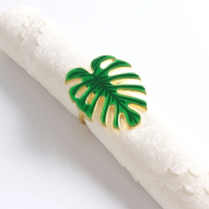 Vue détaillée du rond de serviette feuille de monstera en émail vert sur fond en dentelle