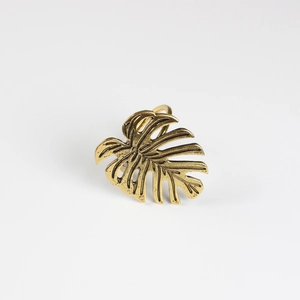 Détail du rond de serviette en feuille de monstera avec finition dorée et nervures