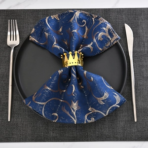 Elegant gold crown napkin ring with dots on a navy jacquard napkin for wedding decor