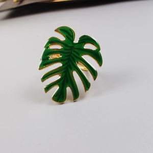 Détail de l'anneau de serviette en feuille de monstera émaillée verte avec bordure dorée