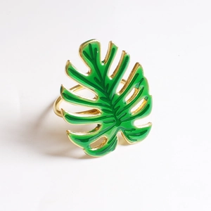 Détail du rond de serviette feuille de monstera verte avec finition dorée et émail