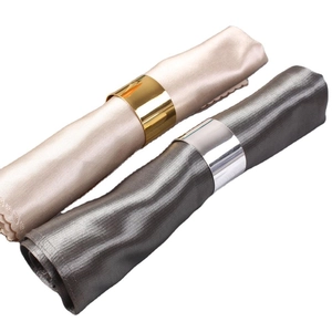 Modern gold and silver napkin rings set with smooth mirror finish on satin fabric