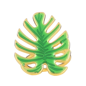 Rond de serviette en forme de feuille de Monstera dorée et émail vert sur fond blanc
