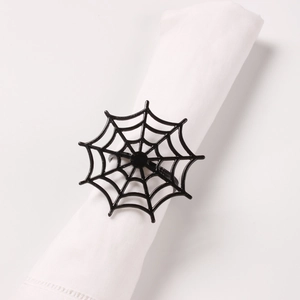 Detail eines schwarzen Spinnennetz-Serviettenrings auf weißem Tuch für Halloween
