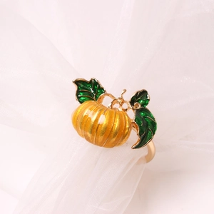 Golden alloy napkin ring featuring a vibrant yellow enamel pumpkin with green leaves
