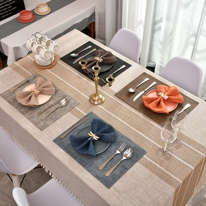 Macro detail of textured cotton linen placemats and striped table runner for table decor