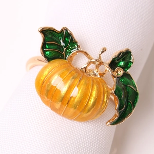 Golden pumpkin napkin ring with orange enamel and green leaves for festive harvest decor
