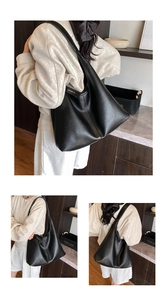 Close-up of black lychee grain leather hobo bag with gold metal logo and shoulder strap