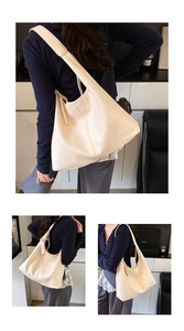Detailed view of cream lychee-textured tote bag showing premium leather grain and wide strap