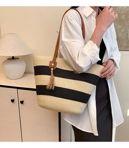 Détail du sac cabas en paille tissé à rayures noires et anses en cuir marron