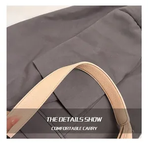 Detail view of the beige lychee texture leather handle with neat stitching on a tote bag