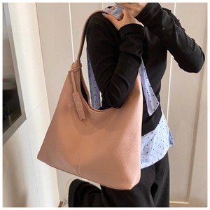 Close-up of litchi grain texture on dusty pink oversized tote bag with a leather tag