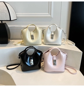 Bolsos tipo cubo en cuero brillante beige, blanco, negro y rosa con cierres metálicos