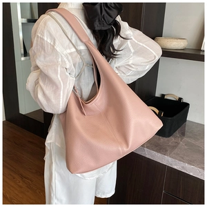 Close-up of pink tote bag with lychee texture and stitching on shoulder strap