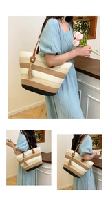 Détail d'un grand sac cabas en paille rayée avec anses en cuir marron et pompon décoratif