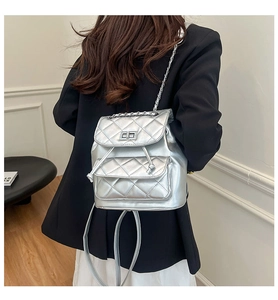 Detail of silver quilted backpack featuring metallic faux leather and chain straps