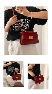 Detail view of red leather crossbody bag with gold twist lock and woven handle strap