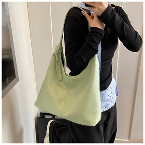 Detail of light green pebble leather hobo bag showing large capacity and shoulder strap