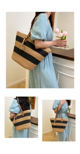 Détail du grand sac cabas en paille à rayures noires, anses en cuir et pompon décoratif