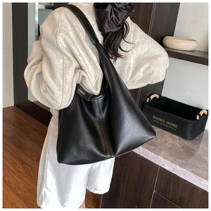 Detailed back view of large black lychee texture tote bag worn over the shoulder
