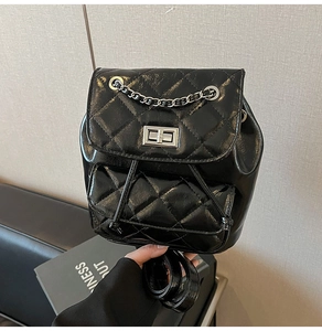 Detail of mini black quilted backpack featuring glossy leather and metallic turn-lock