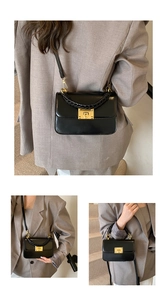 Detail of black glossy square bag with golden turn-lock closure and woven handle