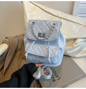 Detail of light blue quilted mini backpack with metallic chain and silver twist lock