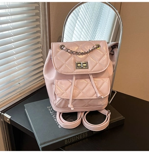 Detail of light pink quilted leather backpack with metal chain and turn-lock closure