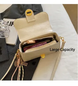 Vue intérieure du sac à bandoulière crème montrant l'espace pour portefeuille et maquillage