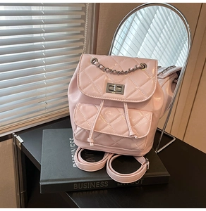 Detail of pink quilted patent leather backpack with silver chain and twist-lock