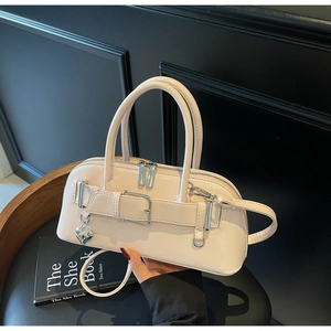 Détail d'un sac à bandoulière rose avec boucle argentée et breloque en cœur miroir