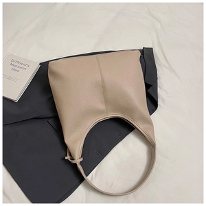 Detail shot of apricot lychee pattern leather bucket bag on a white fabric background