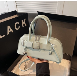 Détail du sac à main vert menthe avec pendentif cœur argenté et sangle décorative