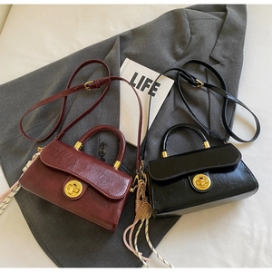 Détail de la texture cuir huilé vintage avec fermoir en métal doré sur petits sacs
