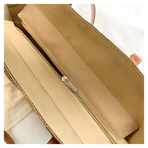 Détail intérieur du sac cabas en paille avec compartiment zippé et anses en cuir