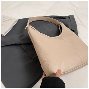 Close-up of beige lychee texture leather tote bag with elegant minimalist shoulder strap