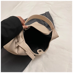 Detail of off-white lychee texture leather tote with magnetic buckle and brand strap