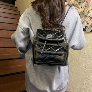Black quilted leather mini backpack with silver twist lock and chain strap details