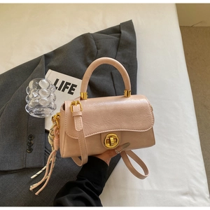 Détail du sac à main rose avec fermoir rotatif doré et pendentif en corde tressée
