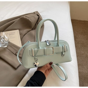 Détail du sac à main vert menthe avec double fermeture éclair et pendentif en cœur