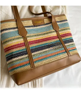 Macro shot of striped woven straw tote with premium brown leather handles and logo patch