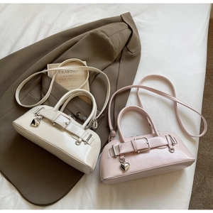 Vue détaillée de sacs à bandoulière carrés en beige et rose avec breloques en cœur