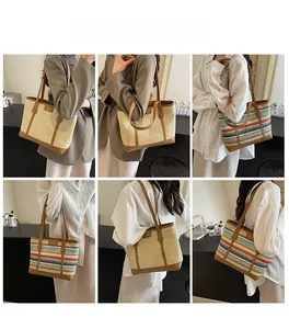 Detail of straw tote bag in beige and rainbow stripes with brown leather trim