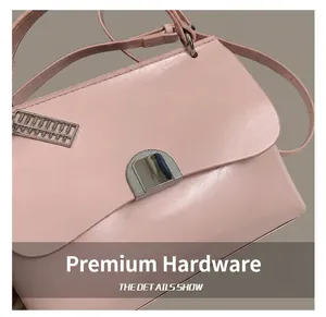 Detailed close-up of pink leather tote bag featuring a round metal lock and abacus charm
